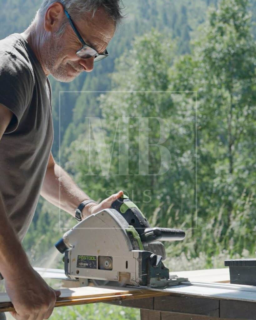 Artisan MBsols coupant une lame à la scie plongeante sur une terrasse en montagne